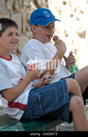 Les enfants de manger de la malbouffe Banque D'Images