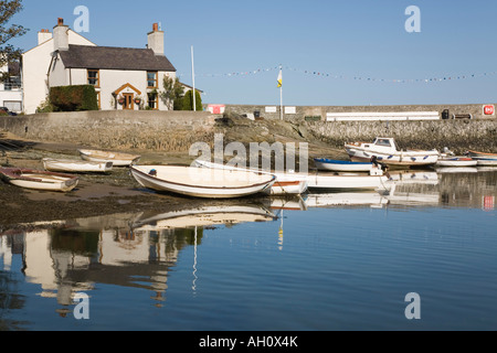 Cemaes Anglesey Pays de Galles UK Chalets et bateaux amarrés reflète dans l'eau de mer dans le port le plus au nord pittoresque village gallois Banque D'Images