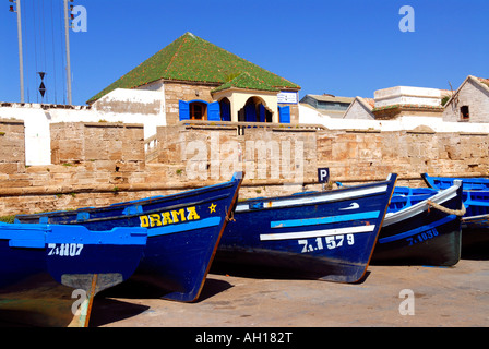 Essaouira Maroc , Port , scène africain typique de vieux bateaux de pêche traditionnels bleu en face de la maison de la douane sur quai Banque D'Images