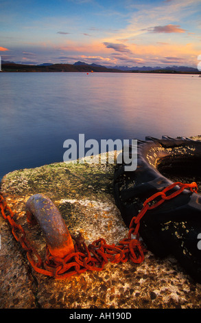 Chaîne rouillée attachée au vieux pneu sur une jetée par Loch Ewe à Ormiscaig Aultbea près de Gairloch Wester Ross Scotland UK Banque D'Images