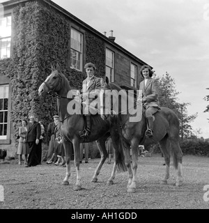 OLD VINTAGE SNAPSHOT FAMILLE PHOTOGRAPHIE DE JEUNE HOMME ET FEMME PORTANT DES VÊTEMENTS COUNTRY TWEED ASSIS SUR DES CHEVAUX Banque D'Images