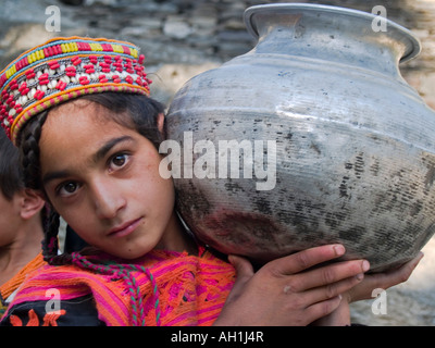 Un Kalasha fille et sa cruche d'eau de la vallée de Rumbur Pakistan Banque D'Images