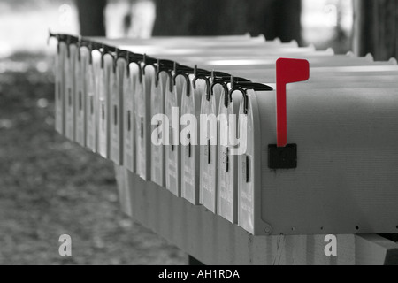 Rangée de boîtes aux lettres en noir et blanc avec drapeau rouge soulevé Banque D'Images