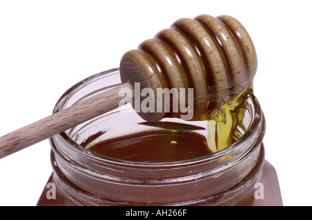 Pot de miel et le balancier se découpant sur fond blanc Banque D'Images