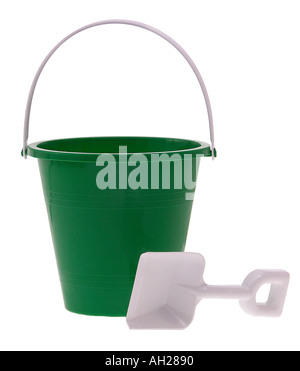 Seau vert et une pelle de sable blanc se découpant sur fond blanc Banque D'Images