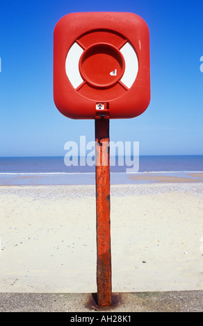 Close up de l'équipement de sauvetage rouge sur rouge post avec plage de sable blanc et bleu et gris ondulation calme mer et ciel bleu clair Banque D'Images