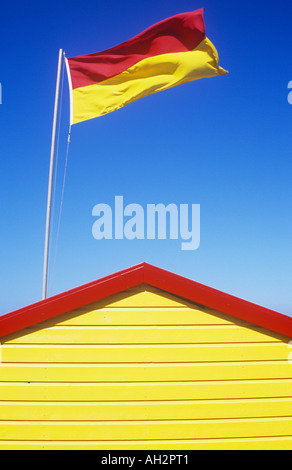 Partie d'une cabane de sauveteur peint en couleurs en surveillance aquatique avec une zone jaune et rouge sous drapeau patrouille palpitations dans Breeze Banque D'Images