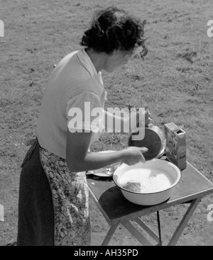 OLD VINTAGE PHOTO DE FAMILLE INSTANTANÉ DE JEUNE FEMME LAVE LE MOULE SUR TABLE DANS LE CHAMP À CAMP SITE Banque D'Images