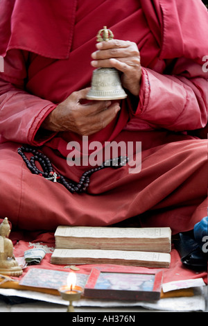 Moine bouddhiste tibétain chantant cloche qui sonne sur l'extérieur de la rue Stupa de Swayambhu, Katmandou, Népal Banque D'Images