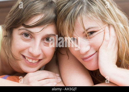 Portrait de deux jeunes femmes couchée sur le lit et souriant Banque D'Images