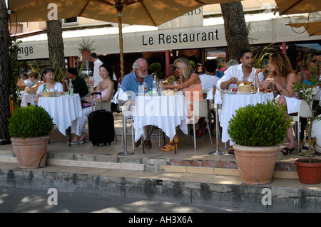 Les personnes mangeant dans un restaurant au Vieux Port de St Tropez France Banque D'Images