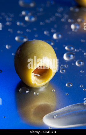 Olives et éclaboussures de liquides sur une table en métal Banque D'Images