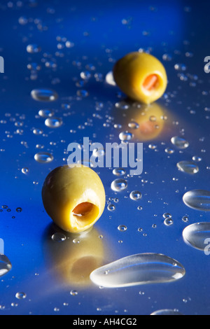 Olives et éclaboussures de liquides sur une table en métal Banque D'Images