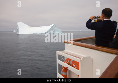 Direction le pont de bateau de croisière de prendre photo de gros iceberg passant sur une mer calme dans la baie de Disko, sur la côte ouest du Groenland Banque D'Images