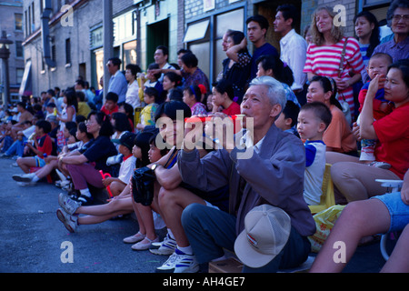 Personnes âgées Chinese man se trouve sur trottoir jouant de la flûte en plastique lors de l'Assemblée International District Seafair Parade à Seattle Washington Banque D'Images