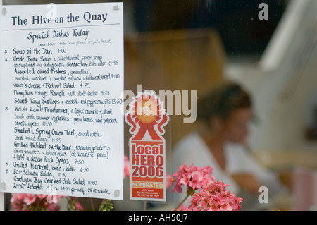 La Ruche sur le quai restaurant menu fenêtre en Aberaeron Ceredigion Pays de Galles - femme assise à l'intérieur hors focus Banque D'Images