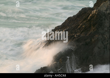 Surf autour de la base de rochers à Bedruthan Steps allumé au coucher du soleil nr Newquay Cornwall Grande-bretagne Banque D'Images