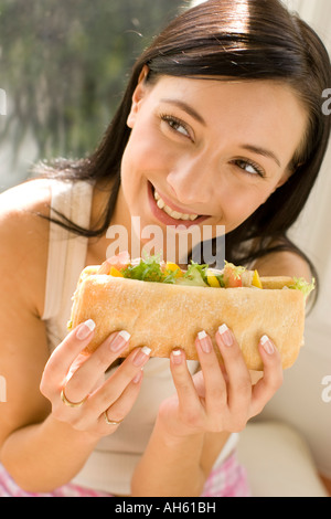 Brunette girl eating sandwich sain Banque D'Images