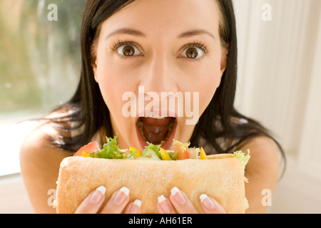 Brunette girl eating sandwich sain Banque D'Images