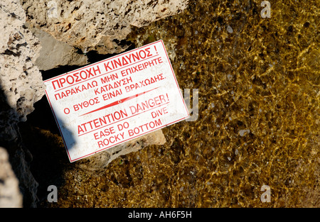 Le signe de danger sur promontoire rocheux de la plage de Nissi près de Ayia Napa sur l'île Méditerranéenne de Chypre UE Banque D'Images