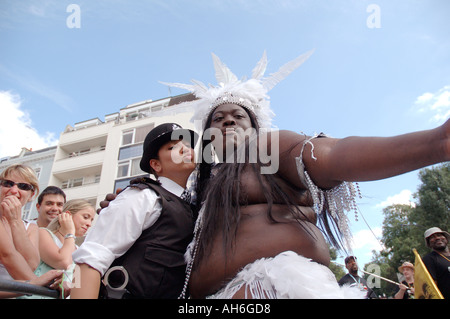 Policewoman interagissant et posant avec très grand danseur noir à Notting Hill Carnival. Banque D'Images