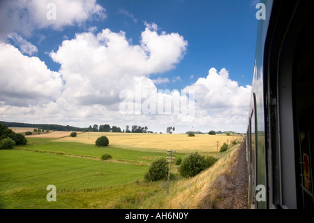 Voir par la fenêtre d'un train en marche sur les champs l'Est de la Pologne Europe Banque D'Images