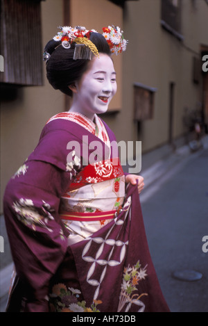 Une maiko en pleine kimono et un miroir de partir à une soirée de rendez-vous dans le quartier de Gion Hanamachi de Kyoto Banque D'Images