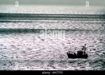Silhouette d'un bateau de pêche en mer Banque D'Images