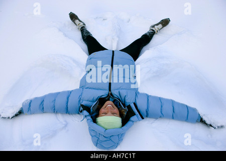 High angle view of a Mid adult woman lying in the snow Banque D'Images
