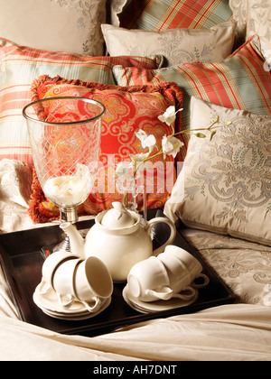 Plateau avec thé classique en porcelaine blanche sur lit décoré avec plein d'oreillers interior design Banque D'Images
