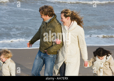 Couple marchant avec leur fils et fille sur la plage