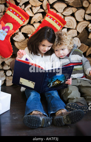 Girl and boy reading a book Banque D'Images