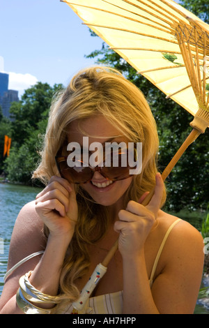 Portrait of a young woman peering over Sunglasses and smiling Banque D'Images