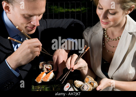 Jeune couple eating sushi Banque D'Images