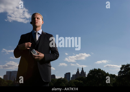 Low angle view of a businessman holding a mobile phone, New York City, New York, USA Banque D'Images