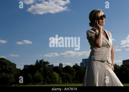 Low angle view of a young woman talking on a mobile phone and smiling, New York City, New York, USA Banque D'Images