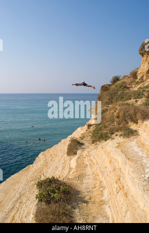 Jeune homme de plonger dans la mer depuis une falaise de l'île de Corfou Sidari, Grèce Banque D'Images