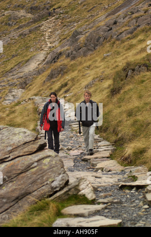 Il marche sur la piste des mineurs du sommet du Snowdon après avoir monté via la Crèche Goch ridge Gwynedd North Wales UK Banque D'Images