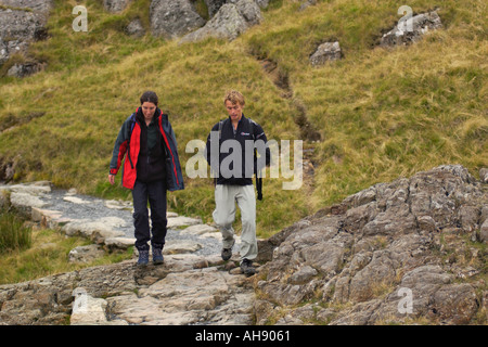 Il marche sur la piste des mineurs du sommet du Snowdon après avoir monté via la Crèche Goch ridge Gwynedd North Wales UK Banque D'Images