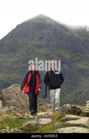 Il marche sur la piste des mineurs du sommet du Snowdon derrière après avoir remonté par la Crèche Goch ridge Gwynedd North Wales UK Banque D'Images