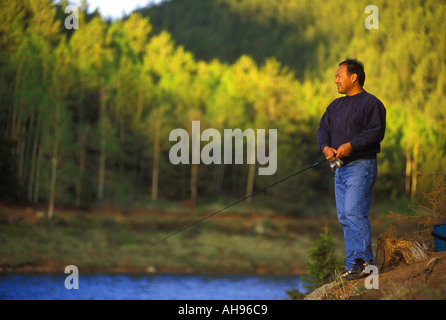 L'homme pêche en lac montagne Banque D'Images