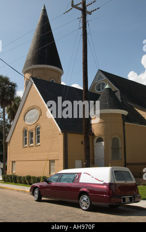 Vintage Bourgogne et corbillard blanc garé à l'extérieur de l'église baptiste de la ville antique à Augustine, Floride, États-Unis. Banque D'Images