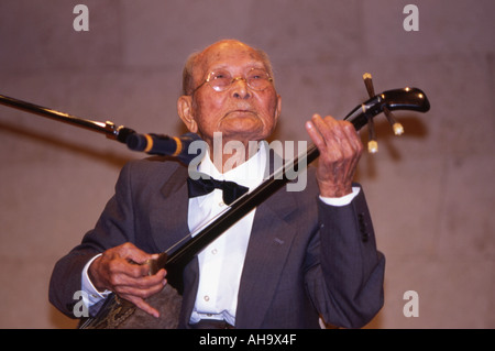 90 ans quelque chose de l'homme joue le sanshin Okinawa shamisen d'Okinawa ont Okinawaïens l'espérance de vie la plus longue au monde Banque D'Images