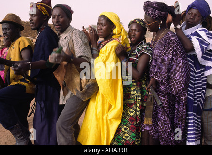 Les hommes et les femmes Dogon dance en procession lors d'une fête de village, au Mali Banque D'Images