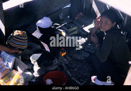 Femme népalaise dans la cuisine où la glace est fondue sur la cheminée dans le bas Pisang village Népal Banque D'Images