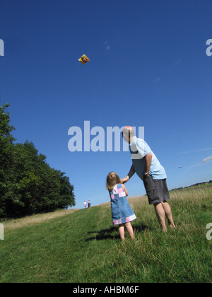 Jeune fille flying kite avec le père Banque D'Images