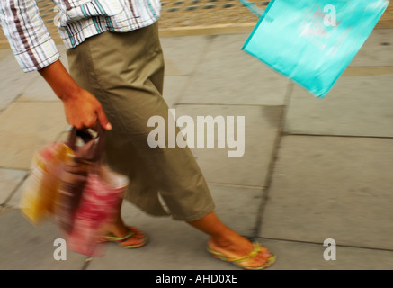 Femme de marcher le long de Regent Street London with shopping bags Banque D'Images