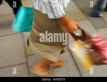 Femme de marcher le long de Regent Steet London with shopping bags Banque D'Images