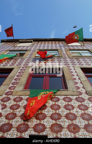 Les drapeaux nationaux portugais sont suspendus devant les fenêtres d'un immeuble résidentiel avant le match international de football dans la ville de Porto au Portugal Banque D'Images