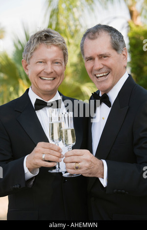 Young gay couple toasting each other with champagne Banque D'Images